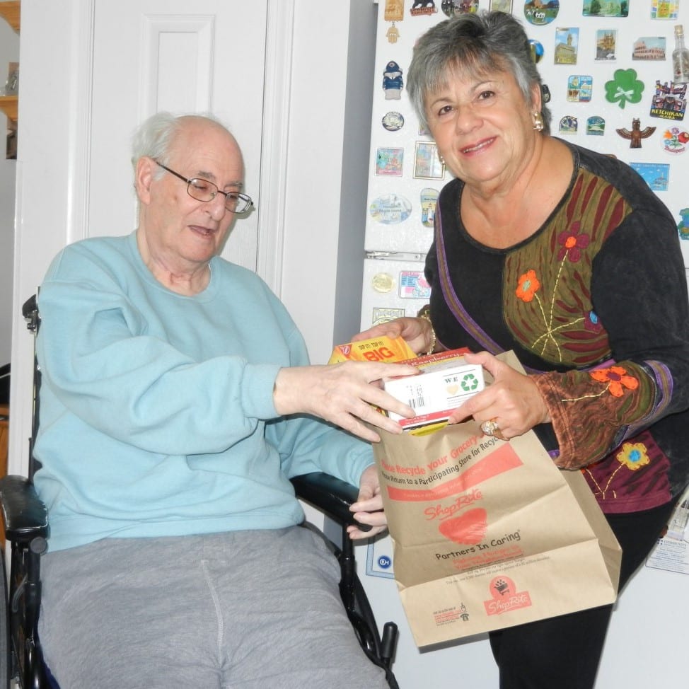 Photo: CVCJ Volunteer handing groceries to a recipient