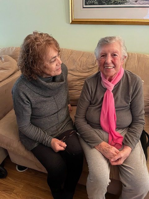 Caregiver Volunteer sitting next to an older woman