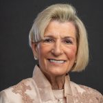 Woman with short blonde hair wearing a peach top